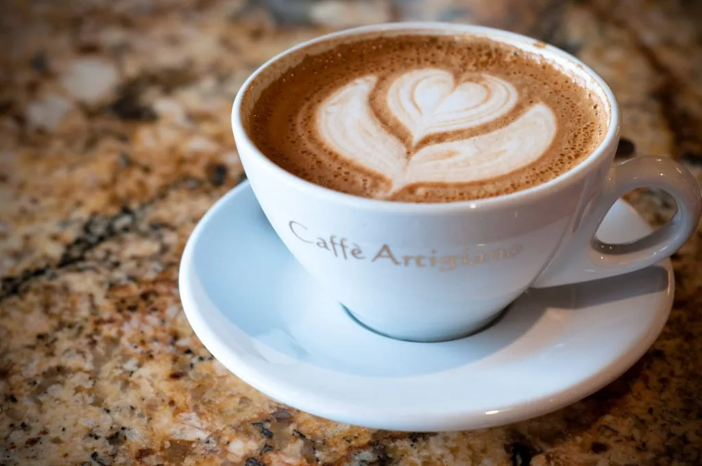 Cappuccino with a heart of latte art in a white cup and saucer