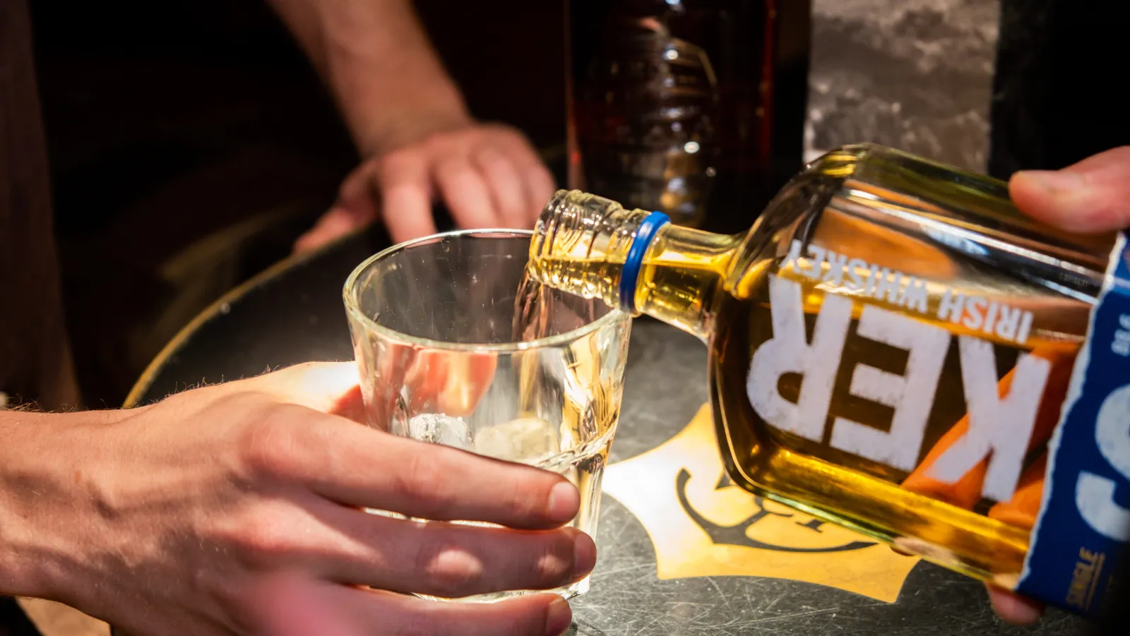 Whisky skænkes i en gæsts glas under en whiskysmagning